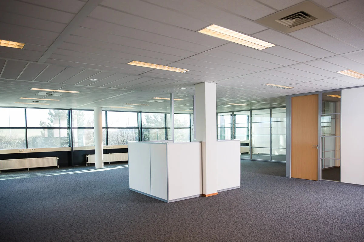 Modern, licht en leeg kantoorpand aan de Laan van ’s-Gravenmade met glazen wanden en systeemplafond.